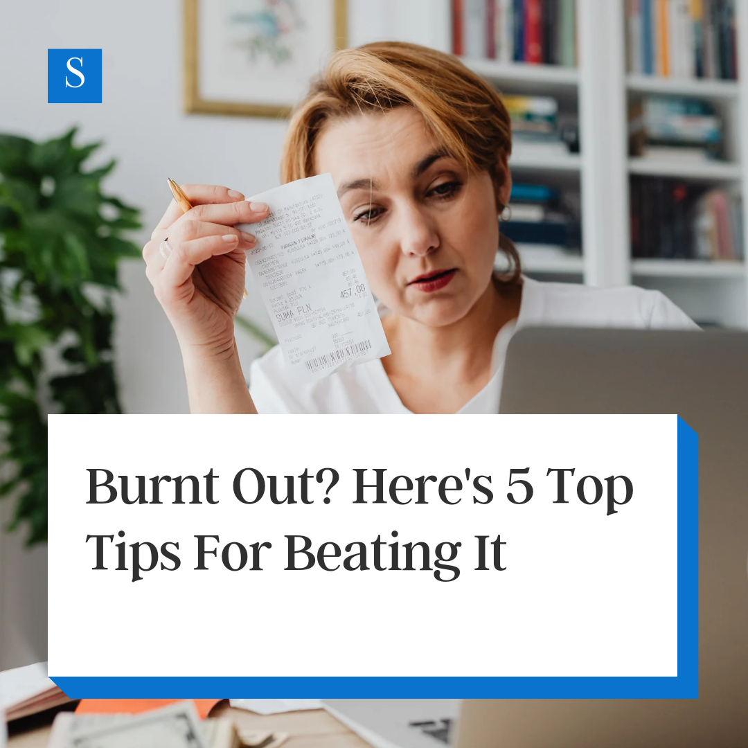 Woman looks on at her computer frustrated. She holds a receipt in her hand. A block of white features black text inside of it that says "Burn out? Here's 5 Top Tips For Beating It."