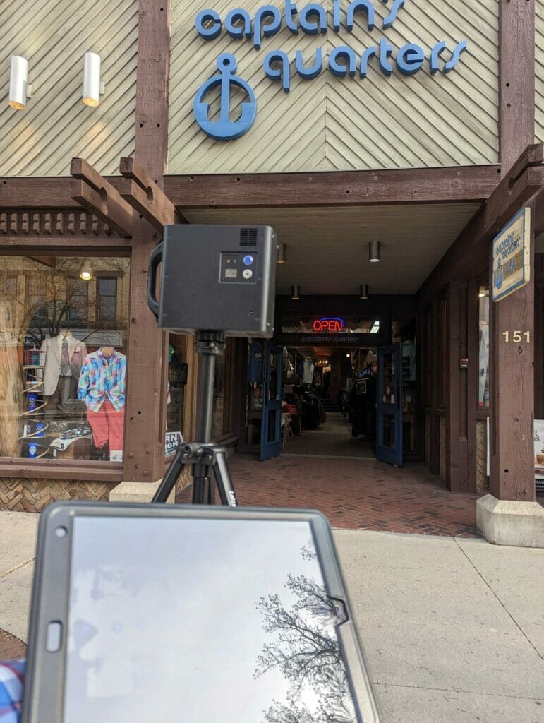 A tablet and phone are shown outside of a store front to take images. This is a project photo. 